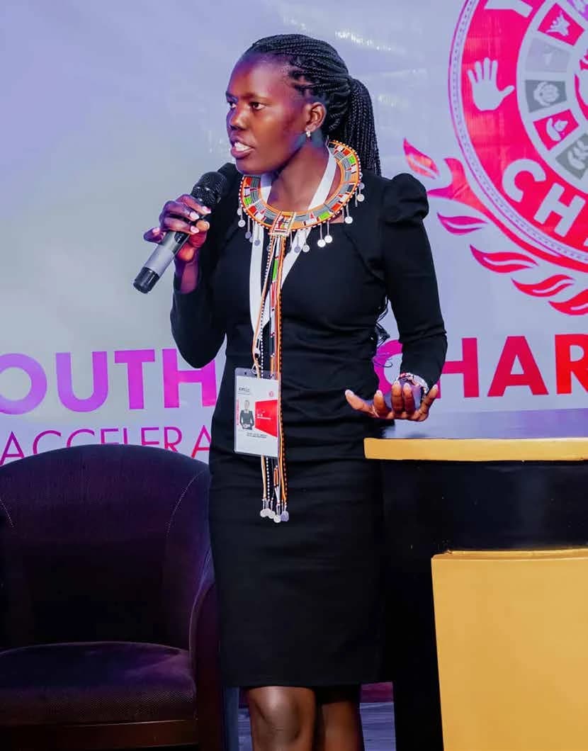 Sharon Ochieng speaking into a microphone at a conference